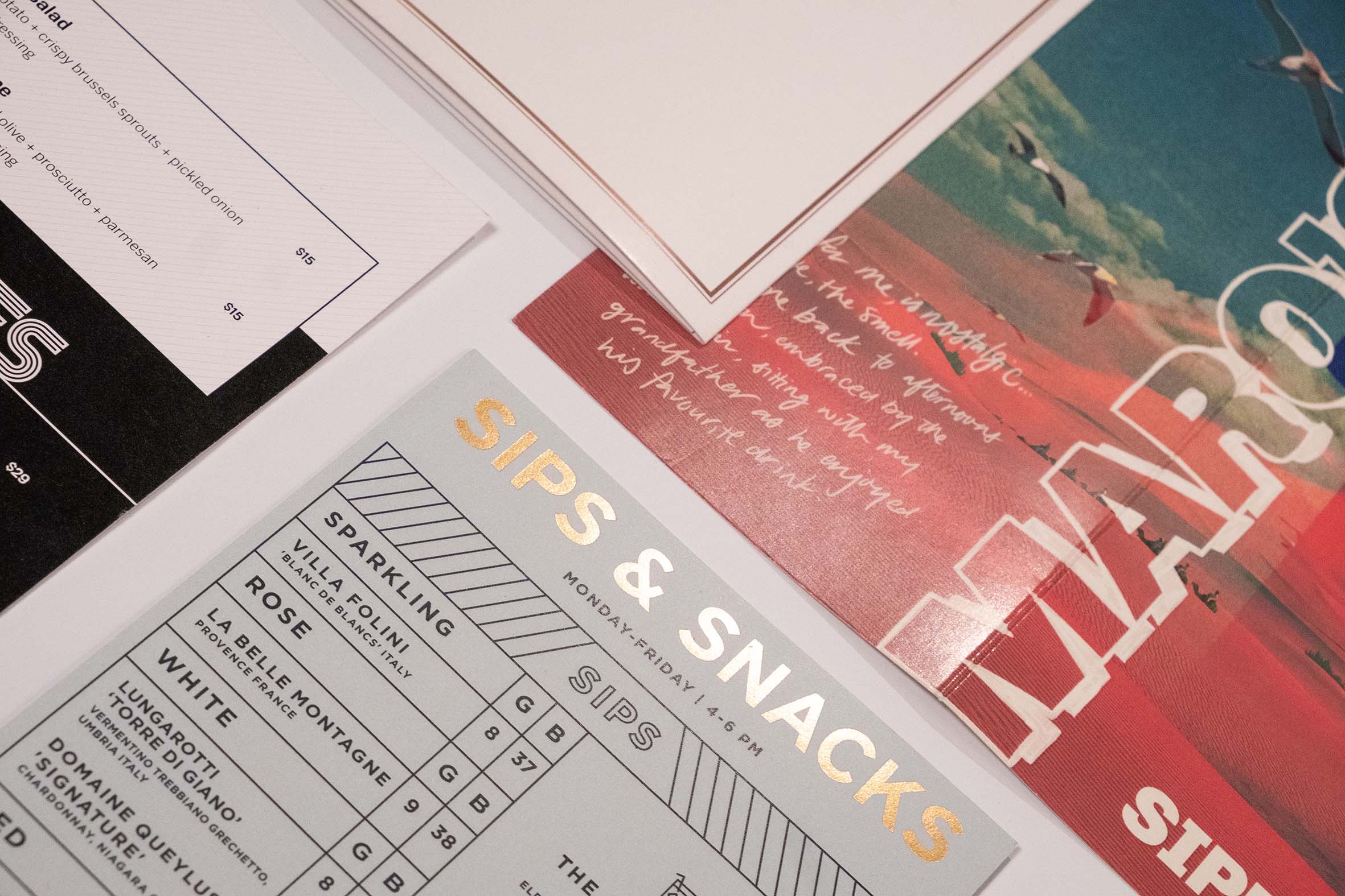A close-up arrangement of colourful printed menus and promotional pieces.